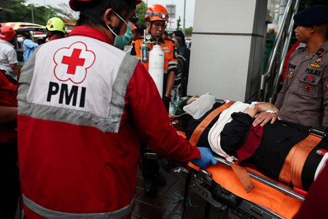Sejumlah petugas penyelamat mengevakuasi seorang korban luka pascatabrakan maut yang melibatkan kereta komuter (Commuter Line) dan kereta api jarak jauh di Bekasi, pinggiran Jakarta, Selasa (28/04/2026). Foto: Willy Kurniawan/REUTERS
