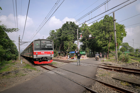 Arpin (40) menjaga pintu perlintasan kereta api sebidang di kawasan TPU Tanah Kusir, Jakarta Selatan, Kamis (30/4/2026). Foto: Jamal Ramadhan/kumparan