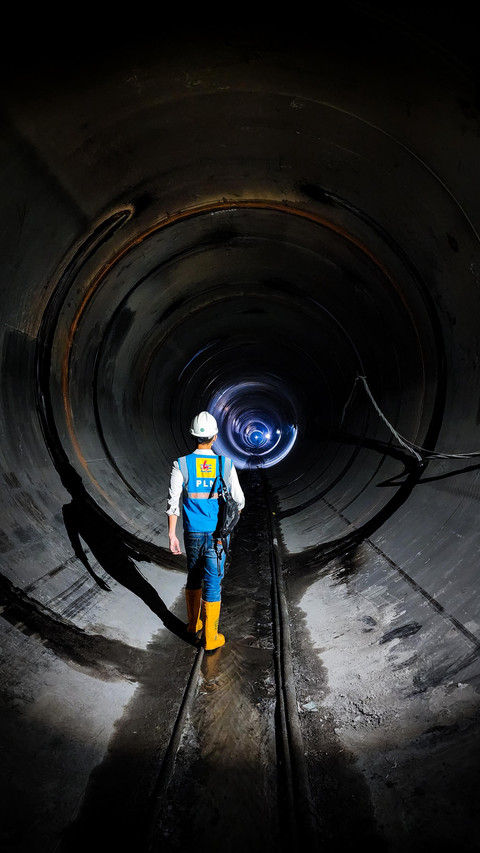 Ilustrasi petugas PLN sedang mengecek progres pembangunan headrace tunnel sebagai jalan masuk utama air sebelum masuk ke powerhouse dan menggerakkan turbin pada salah satu proyek Pembangkit Listrik Tenaga Air (PLTA). Secara kontinu, PLN terus melakukan penguatan infrastruktur transisi energi melalui peningkatan utilisasi energi baru terbarukan (EBT) yang tersebar di seluruh wilayah Indonesia. Foto: Jefrinson Tampubolon