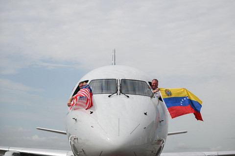 Pilot American Airlines Penerbangan 3599 mengibarkan bendera Venezuela dan AS sebelum lepas landas menuju Caracas dari Bandara Internasional Miami, Florida, (30/4/2026). Foto: Chandan Khanna/AFP