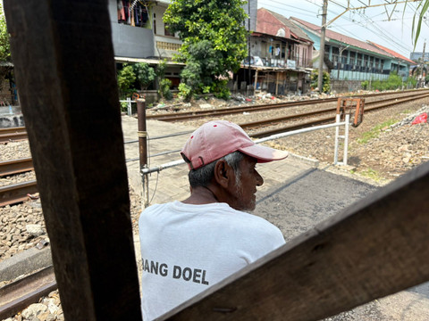 Babeh Ismail atau yang kerap disapa Babeh Is penjanga lintasan sebidang di kawasan Tebet Timur Dalam, Sabtu (2/5/2026). Foto: Rayyan/Kumparan