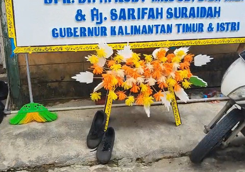 Papan bunga ucapan duka dari Gubernur Kaltim Rudy Mas'ud dan sepatu kekecilan milik Mandala Rizky Syaputra. Foto: kumparan