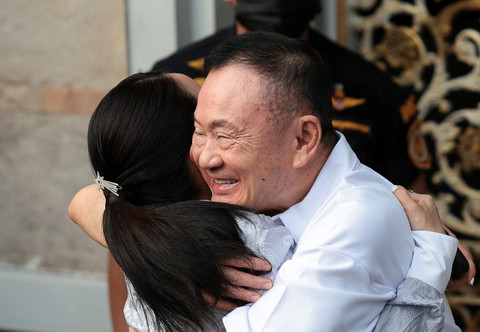 Mantan Perdana Menteri Thailand Thaksin Shinawatra memeluk putrinya, mantan Perdana Menteri Thailand Paetongtarn Shinawatra, setelah dibebaskan dengan status parole setelah menjalani delapan bulan dari hukuman satu tahunnya di Penjara. Foto: REUTERS/Chalinee Thirasupa