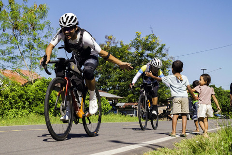 Ultra cyclist sejenak terhibur oleh keramahan anak-anak di tengah upaya taklukkan tanjakan terjal di pulau Flores. Foto: Dok. Istimewa