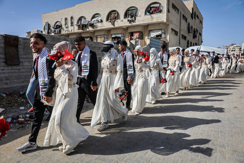 Pasangan pengantin Palestina berkumpul dalam acara pernikahan massal yang diselenggarakan oleh Turkish Humanitarian Relief Foundation (IHH) di Kota Gaza (11/5/2026). Foto: OMAR AL-QATTAA/AFP