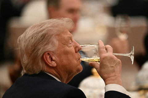 Presiden AS Donald Trump minum saat menghadiri jamuan makan malam kenegaraan bersama Presiden Tiongkok Xi Jinping di Balai Besar Rakyat di Beijing, Kamis (14/5/2026). Foto: Brendan Smialowski/AFP