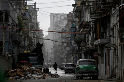 Seorang pria berjalan di jalanan di tengah hujan di Havana, Kuba, 17 Maret 2026. Foto: Norlys Perez/ REUTERS
