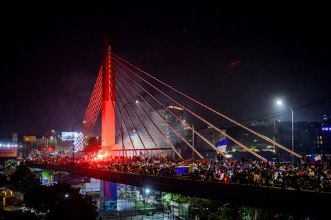 Sejumlah Bobotoh atau suporter Persib Bandung menyalakan suar saat melakukan konvoi di Jembatan Layang Mochtar Kusumaatmadja Bandung, Jawa Barat, Minggu (17/5/2026). Foto: Raisan Al Farisi/ANTARA FOTO