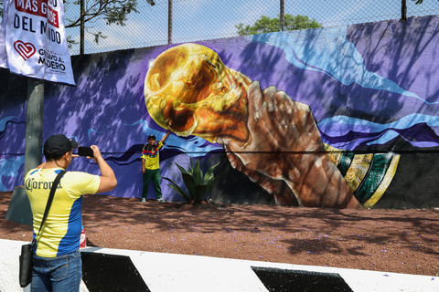 Seorang anak berpose untuk foto di depan mural bertema sepak bola seluas lebih dari 200 meter persegi, yang bertujuan untuk memecahkan Rekor Dunia Guinness sebelum Piala Dunia 2026, di Mexico City, Meksiko, 24 Mei 2026. Foto: REUTERS/Luis Cortes