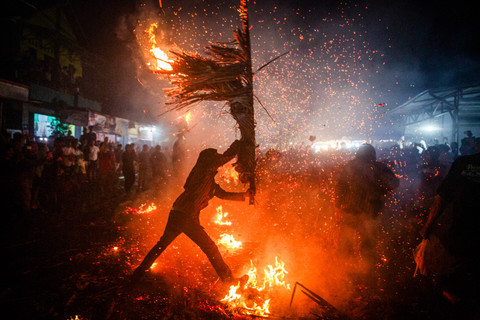 Para peserta saling memukul dengan obor yang terbuat dari daun kelapa kering selama ritual Perang Obor tradisional di Tegalsambi, Jawa Tengah, Senin (26/5/2026). Foto: Devi Rahman/AFP