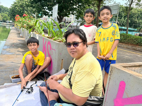 Manalu (42) dan ketiga anaknya, pengunjung Danau Sunter. Foto: Kevin Daniel/kumparan