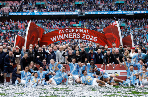 Para pemain dan staf Manchester City merayakan kemenangan dengan trofi Piala FA setelah mengalahkan Chelsea dalam babak final di Stadion Wembley, London, Inggris, Sabtu (16/5/2026). Foto: Peter Cziborra/REUTERS