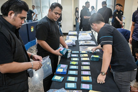 Petugas merapikan barang bukti kasus penipuan perjalanan umrah saat rilis di Polda Metro Jaya, Jakarta, Selasa (2/6/2026). Foto: Sulthony Hasanuddin/ANTARA FOTO 
