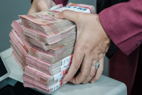 Sejumlah uang kertas rupiah Indonesia difoto di sebuah tempat penukaran mata uang di Jakarta, Kamis (4/6/2026), setelah nilai tukar rupiah melemah hingga melampaui angka 18.000 per dolar AS untuk pertama kalinya. Foto: Yasuyoshi Chiba/AFP