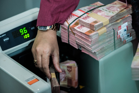 Sejumlah uang kertas rupiah Indonesia difoto di sebuah tempat penukaran mata uang di Jakarta, Kamis (4/6/2026), setelah nilai tukar rupiah melemah hingga melampaui angka 18.000 per dolar AS untuk pertama kalinya. Foto: Yasuyoshi Chiba/AFP