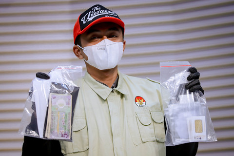 Petugas menunjukkan barang bukti OTT dugaan korupsi pengurusan izin tinggal WNA saat konferensi pers yang dipimpin Ketua KPK Setyo Budiyanto di Gedung Merah Putih KPK, Jakarta, Kamis (4/6/2026). Foto: Jamal Ramadhan/kumparan