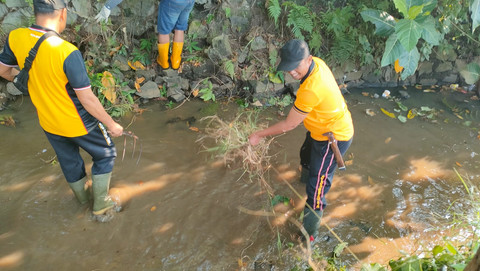 Personel Polsek Cisauk menggelar aksi bersih-bersih sungai di Jalan stasiun KA Cicayur, Cisauk, Tangerang, Kamis (11/6/2026). Foto: Dok. Istimewa