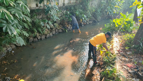 Personel Polsek Cisauk menggelar aksi bersih-bersih sungai di Jalan stasiun KA Cicayur, Cisauk, Tangerang, Kamis (11/6/2026). Foto: Dok. Istimewa