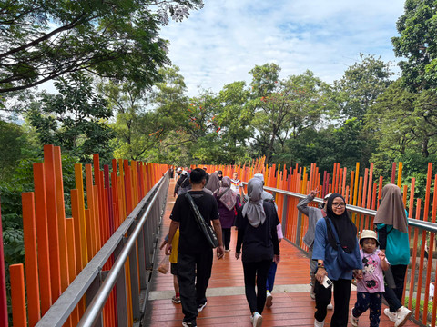 Sejumlah warga berjalan menikmati suasana akhir pekan di Infinity Link Bridge Tebet Eco Park, Jakarta Selatan, Minggu (14/6/2026). Foto: Nauval Pratama/kumparan