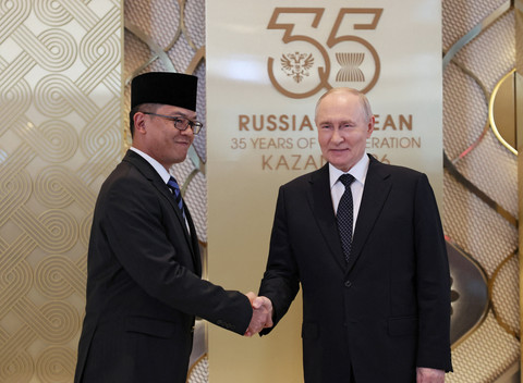Presiden Rusia Vladimir Putin berjabat tangan dengan Menteri Luar Negeri Indonesia Sugiono dalam upacara penyambutan resmi para kepala delegasi yang berpartisipasi dalam KTT Rusia-ASEAN di Kazan, Rusia, Rabu (17/6/2026). Foto: Anastasia Barashkova/Reuters 