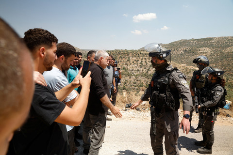 Warga Palestina berdiri di depan petugas penegak hukum Israel selama protes terhadap pemukiman baru Israel di desa Deir Abu Mishal, dekat Ramallah, di Tepi Barat yang diduduki Israel, 19 Juni 2026. Foto: REUTERS/Mohammed Torokman