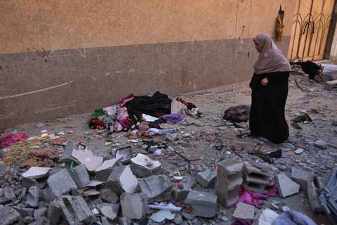 Seorang perempuan memeriksa kerusakan setelah serangan udara Israel menghantam apartemen keluarga Safadi di lingkungan al-Sabra, Kota Gaza, pada Sabtu (20/6). Foto: AFP