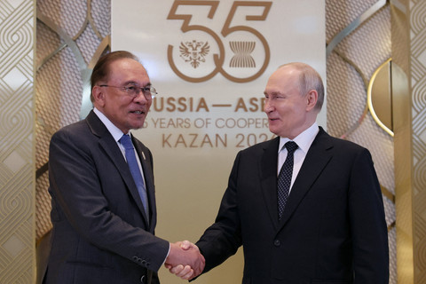 Presiden Rusia Vladimir Putin berjabat tangan dengan Perdana Menteri Malaysia Anwar Ibrahim selama upacara penyambutan resmi untuk kepala delegasi yang berpartisipasi dalam KTT Rusia-ASEAN di Kazan, Rusia, Rabu (17/6/2026). Foto: Anastasia Barashkova/ REUTERS 