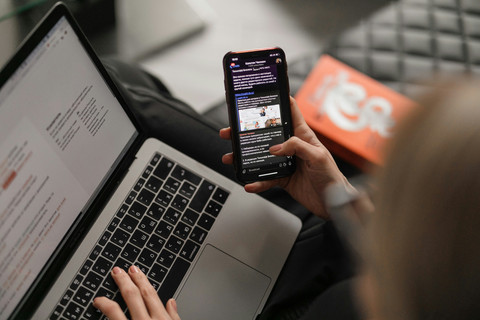 Ilustrasi seseorang menggunakan ponsel dan laptop untuk mengakses informasi di internet. Sumber: Maxim Ilyahov/Unsplash