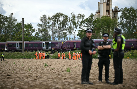 Petugas Kepolisian Transportasi Inggris, petugas Cabang Investigasi Kecelakaan Kereta Api, dan Network Rail bekerja di lokasi tabrakan dua kereta East Midlands Railway (EMR) di selatan Bedford, Inggris tengah (20/6/2026). Foto: Justin Tallis/AFP