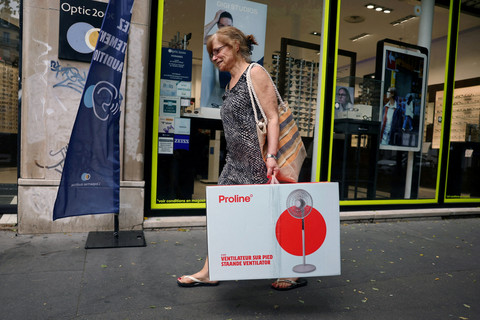 Warga membawa kipas angin listrik saat gelombang panas di Paris, Prancis, Selasa (23/6/2026). Foto: Abdul Saboor/REUTERS