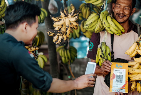 Ilustrasi masyarakat dan pedagang bertransaksi menggunakan QRIS dari aplikasi Livin' by Mandiri. Foto: Dok. Bank Mandiri