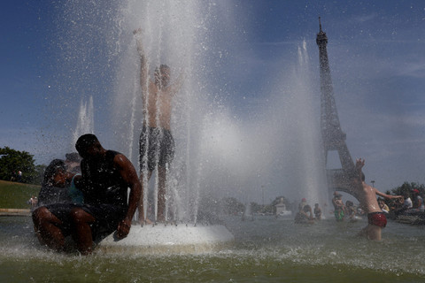 Warga bermain air di Air Mancur Trocadero saat gelombang panas melanda Paris, Prancis, Sabtu (27/6/2026). Foto: Tom Nicholson/REUTERS
