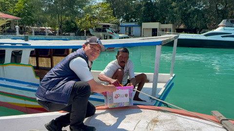 Petugas polisi memberikan bingkisan kepada warga setempat saat perayaan HUT Bhayangkara ke-80 di Pulau Kelapa, Kepulauan Seribu, Rabu (1/7/2026). Foto: Rayyan/Kumparan