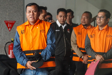 Bupati Kuantan Singingi (Kuansing) Suhardiman Amby (kiri) mengenakan rompi tahanan berjalan menuju mobil tahanan usai menjalani pemeriksaan di Gedung Merah Putih KPK, Jakarta, Rabu (1/7/2026). Foto: Iqbal Firdaus/kumparan