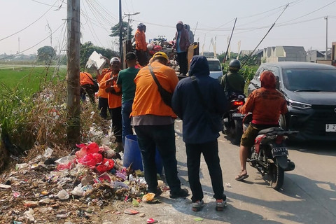 Dinas Lingkungan Hidup (DLH) Kabupaten Bekasi mengangkut sekitar 10 ton sampah yang berserakan di Jalan Raya Pulo Timaha, Kecamatan Babelan. Foto: Dok. Istimewa