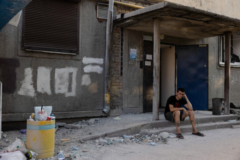 Seorang anak laki-laki duduk di tangga pintu dekat sebuah bangunan tempat tinggal yang rusak akibat serangan udara Rusia di ibu kota Ukraina, Kiev, Kamis (2/7/2026), di tengah invasi Rusia di Ukraina. Foto: TETIANA DZHAFAROVA/AFP