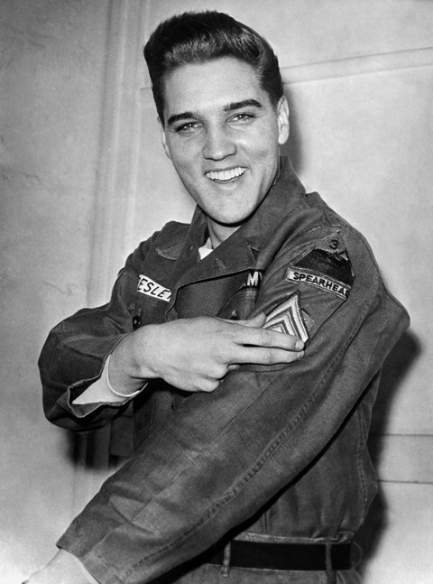 Legenda rock 'n' roll Elvis Presley menunjukkan lencana sersannya di Friedberg, Jerman, (14/2/1960). Foto: Stringer/AFP