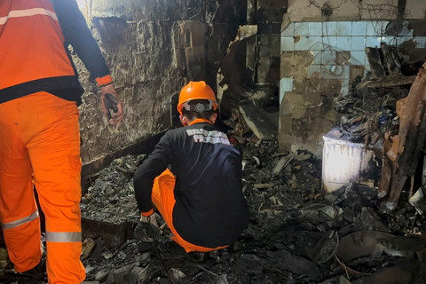 Proses evakuasi jenazah Suratman, pemilik rumah yang terbakar di Jalan Palmerah Utara III, Jakarta Barat, Minggu (5/7/2026). Foto: Abid Raihan/kumparan