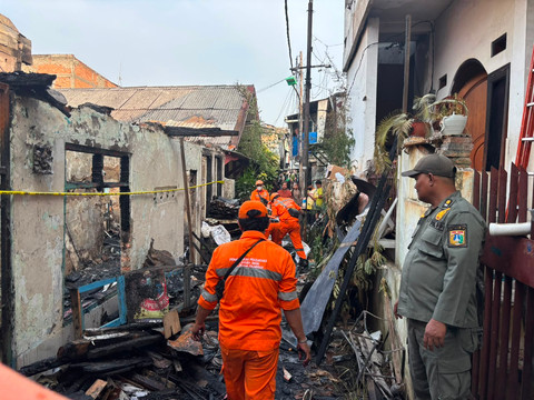 Petugas membersihkan lokasi kebakaran yang menewaskan seorang lansia di Jalan Palmerah Utara III, Jakarta Barat. Senin (6/7). Foto: Pradya Tirta/kumparan