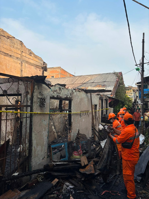 Petugas membersihkan lokasi kebakaran yang menewaskan seorang lansia di Jalan Palmerah Utara III, Jakarta Barat. Senin (6/7). Foto: Pradya Tirta/kumparan