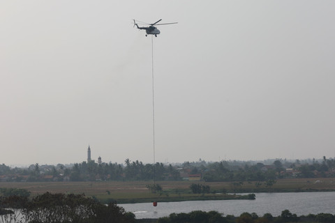 Helikopter dikerahkan untuk memadamkan kebakaran sampah di Tempat Pembuangan Akhir (TPA) Jatiwaringin, Kabupaten Tangerang, Banten, Senin (6/7/2026). Foto: BNPB
