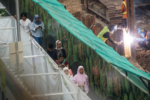 Warga berjalan kaki melewati trotoar darurat di kawasan proyek pengembangan Stasiun MRT Bundaran HI, Jakarta, Selasa (7/7/2026). Foto: Iqbal Firdaus/kumparan