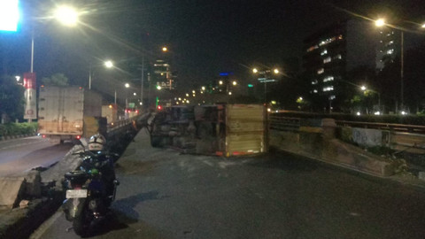 Sebuah truk terguling di Flyover Kuningan, Jalan Gatot Subroto, Jakarta arah Semanggi pada Kamis (9/7) pagi. Foto: X/ @TMCPoldaMetro
