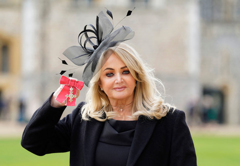 Penyanyi Inggris Gaynor Sullivan alias Bonnie Tyler berpose dengan medali setelah diangkat menjadi Anggota Ordo Kerajaan Inggris (MBE) selama upacara pengukuhan di Kastil Windsor di Windsor, sebelah barat London, pada 1 Februari 2023. Foto: Andrew Matthews / POOL / AFP