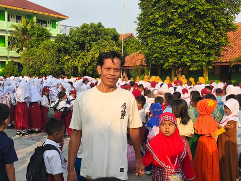 Deli Saputri, Siswa Baru SDN Kalibaru III Bekasi Bersama Ayahnya Satiri Ahmad di Lapangan SDN Kalibaru III, Bekasi, Senin (13/7). Foto: Aditya Nugraha/kumparan