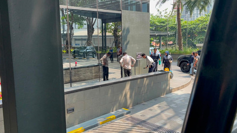 Petugas memeriksa kondisi kaca gedung yang ditabrak mobil di kawasan SCBD, Jakarta Selatan, Rabu (15/7). Foto: Rayyan Farhansyah/kumparan