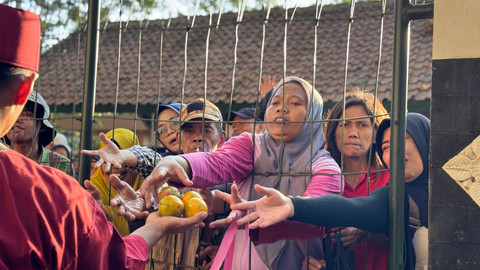 Masyarakat berebut uborampe dalam upacara adat Saparan Bekakak di Ambarketawang, Gamping, Sleman, Jumat (17/7). Foto: Pandangan Jogja/Resti Damayanti