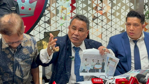 Hotman Paris menunjukkan foto Febri Adriansyah bersama Presiden Prabowo Subianto saat memberikan keterangan kepada wartawan di Gedung Jampidsus Kejagung, Jakarta, Jumat (17/7/2026). Foto: Nauval Pratama/kumparan