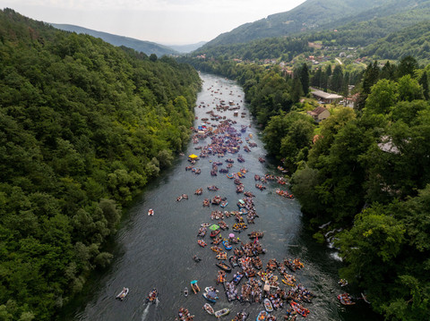 Pemandangan dari drone yang memperlihatkan orang-orang menaiki rakit dan perahu karet selama Regatta Drina tahunan di Sungai Drina dekat Bajina Basta, Serbia, Sabtu (18/7/2026). Foto: Djordje Kojadinovic/REUTERS