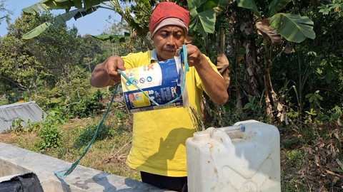 Warga menuangkan air ke dalam jeriken di Dusun Kandangan, Desa Kunjorowesi, Kecamatan Ngoro, Kabupaten Mojokerto, Minggu (19/7/2026). Foto: Dok. Istimewa